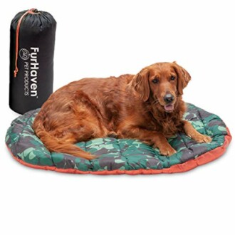 Golden retriever lying on a round pet bed with storage bag.