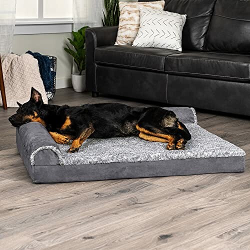 Dog resting on a gray pet bed in a living room.